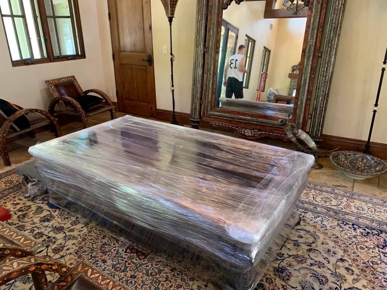 Large antique furniture carefully wrapped in protective plastic by Happy Home Movers