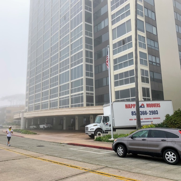 Happy Home Movers truck outside a high-rise building during a move